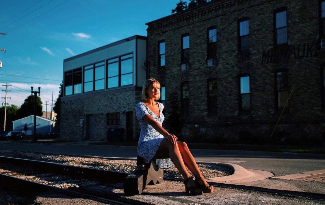 Meg Gunia sitting on her guitar case